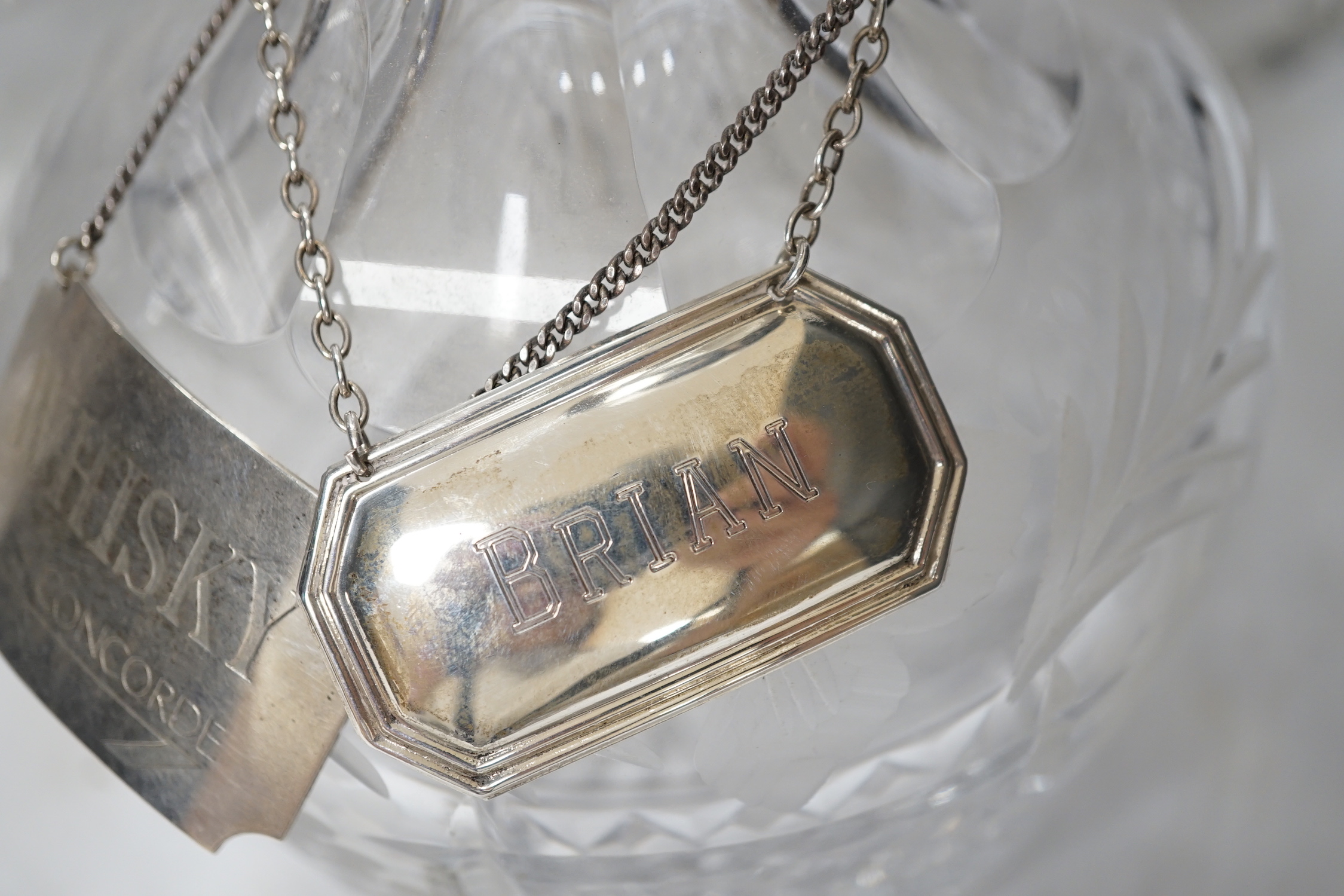 A silver mounted cut glass decanter with silver Concorde label and another label, together with a cut glass urn and a moulded glass basket, urn 28.5cm